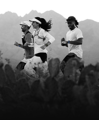Drie mensen die hardlopen in een berggebied, allemaal met een Apple Watch Ultra 3